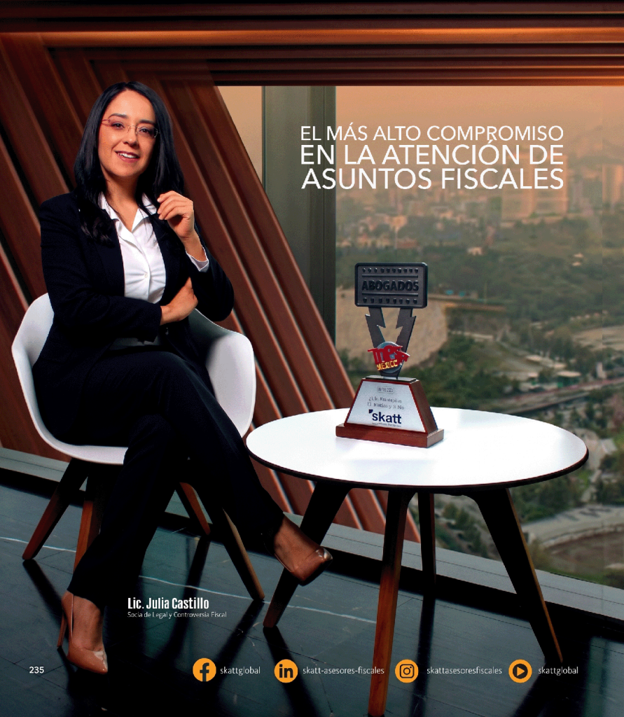 Lic. Julia Castillo, socia de Skatt, experta en controversia fiscal, sentada en oficina moderna con trofeo de "Abogados" y vista a la Ciudad de México.